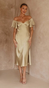 Détail d'une robe élégante en satin champagne avec manches volantées et fente latérale haute