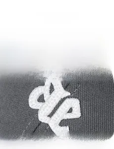 Macro detail of high-density white 3D embroidery on dark grey premium cotton cap fabric