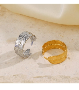 Detailed close-up of gold and silver feather rings with intricate textures on silk