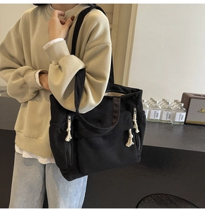 Détail du grand sac cabas en velours côtelé noir avec poche zippée et cordon blanc