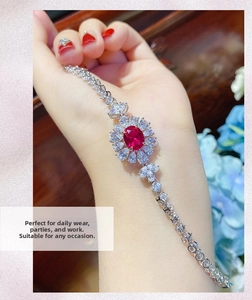 Elegante bracciale in argento con pietra rossa e alone di diamanti sul polso di una modella