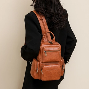 Close-up of a vintage brown PU leather backpack on a model with multi-zipper pockets
