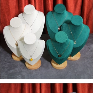 Macro detail of velvet necklace bust displays in dark green and white with wooden bases
