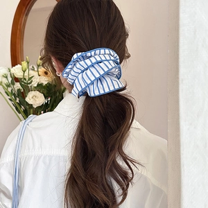 Blue and white striped oversized scrunchie for women shown in a ponytail hairstyle