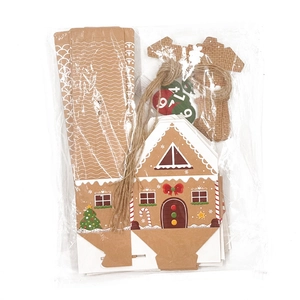 Flat lay of DIY Christmas gingerbread house paper gift box set with jute twine and stickers