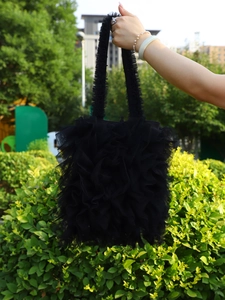 Detailed close-up of a black pleated tulle tote bag with multi-layered ruffle design