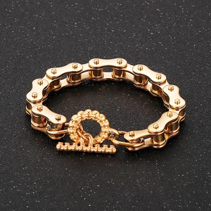 Close-up of golden bicycle chain bracelet with T-bar toggle clasp on black texture