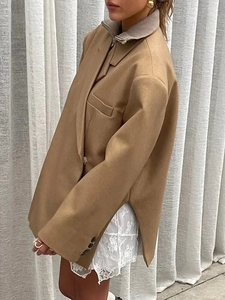 Side view of camel blazer featuring unique side slits and shoulder pads with lace skirt