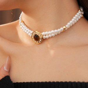 Dettaglio della collana di perle vintage con pietra occhio di tigre e ciondolo di cristallo