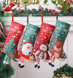 Christmas stockings featuring Santa and snowman patterns hanging on a decorated fireplace