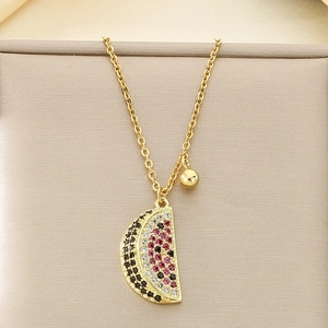 Detail of gold necklace with a crystal-encrusted watermelon slice pendant on a display