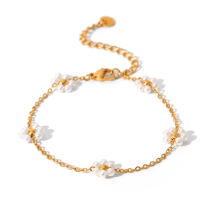 Dettaglio del bracciale a catena dorata con fiori di perle bianche e chiusura a moschettone