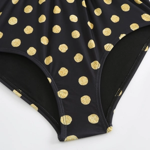 Detail of black swimsuit with golden polka dots and high-quality double-needle stitching
