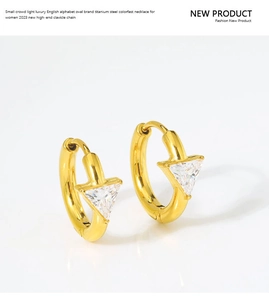 Detail view of gold titanium earrings with sparkling triangle-cut cubic zirconia