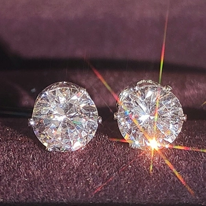 Macro shot of butterfly zircon studs on purple velvet with sparkling rainbow fire effect
