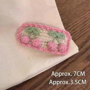 Macro shot of handmade crochet cherry hair clip with pink wave lace and measurements