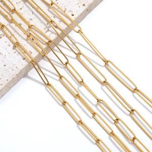 Golden stainless steel oval link paperclip chain for jewelry making on stone backdrop