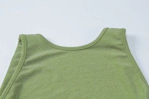 Detail shot of the green sleeveless dress featuring a crew neck and sparkling fabric
