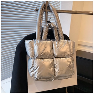 Detail of silver metallic quilted puffer tote bag with soft padded stitch texture