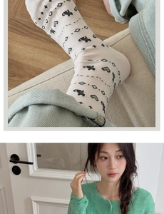 Detailed knit texture of cream Fair Isle socks with black heart patterns and green cardigan