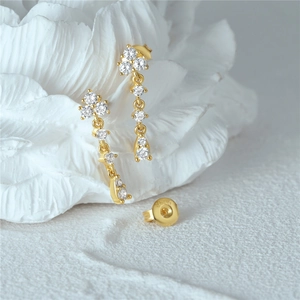 Macro shot of S925 silver golden floral drop earrings with sparkling zircon stones