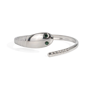 Detailed macro view of silver snake-shaped open bracelet with green cat-eye gemstone eyes