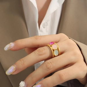 Vintage gold open ring with three oval gemstones in pink and green on a hand
