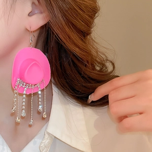 Close-up of pink cowboy hat tassel earrings with sparkling rhinestones on model