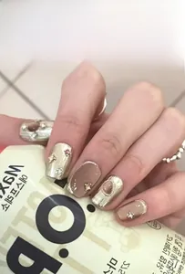 Detail of GN-Series press-on nails with champagne gold cat eye finish and rhinestones