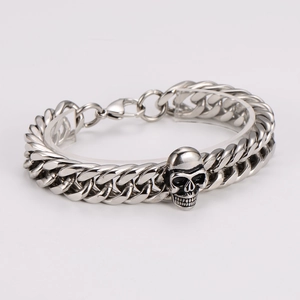 Detailed close-up of a silver stainless steel chunky cuban chain bracelet with skull charm
