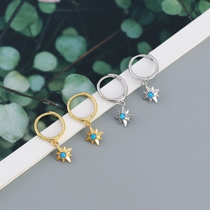 Detailed macro view of gold and silver octagram hoop earrings with blue opal stones