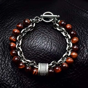 Detail view of red tiger eye beads bracelet with silver metal toggle clasp on black leather