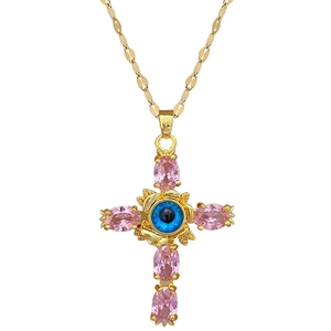 Gold cross necklace with pink gemstones and blue evil eye pendant on a steel chain