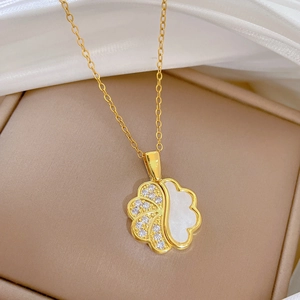 Detail of flower pendant necklace featuring white mother of pearl and crystals on gold chain