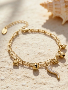 Détail du bracelet double couche plaqué or avec breloques cœur et pendentif corne en zircon