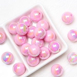 Macro shot of 16mm pink iridescent acrylic round beads for DIY jewelry and crafts