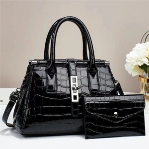 Detail of black crocodile texture patent leather handbag and matching long wallet set