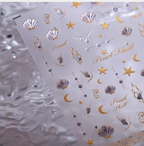 Detail of embossed gold and silver nail stickers with shell and star patterns