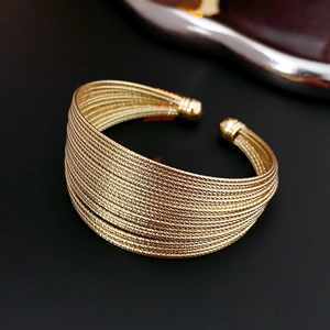 Macro shot of gold plated multi-layer wrap cuff bracelet with textured wire finish