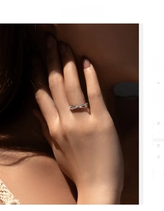 Close-up of S925 sterling silver criss-cross ring with pavé-set stones on hand