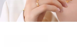 Detail of a 18k gold-plated floral pendant necklace on a model wearing a white suit blazer