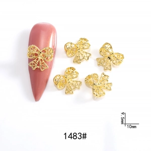 Detail of 9.5mm gold metal hollow bow tie nail art charm with fine mesh texture