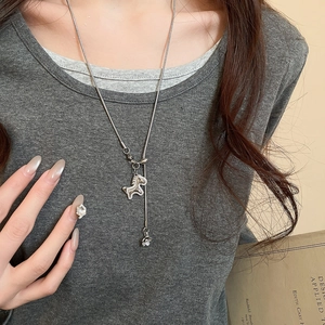 Detail of silver snake chain necklace with sparkling zircon horse and floral charms