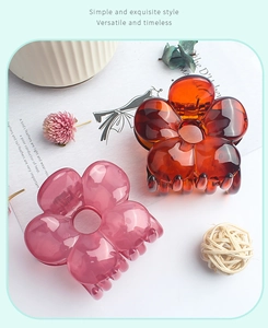 Close-up of elegant flower hair claws in amber and lavender colors with resin texture