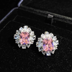 Detailed macro view of pink rectangular crystal stud earrings in a black velvet box