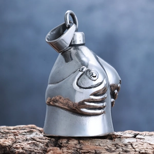 Detailed close-up of a silver female torso pendant resting on a natural wood base