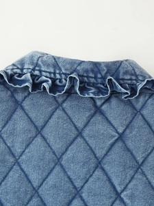 Detail shot of blue denim quilted jacket featuring ruffle trim collar and diamond stitching