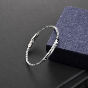 Detailed macro view of the silver stainless steel braided cable bracelet with engraved clasp