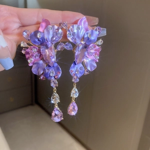 Detail view of purple crystal flower earrings with sparkling rhinestone tassels