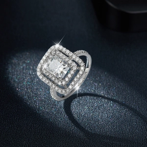 Anello in moissanite 2ct taglio radiant con doppio halo su sfondo blu scuro